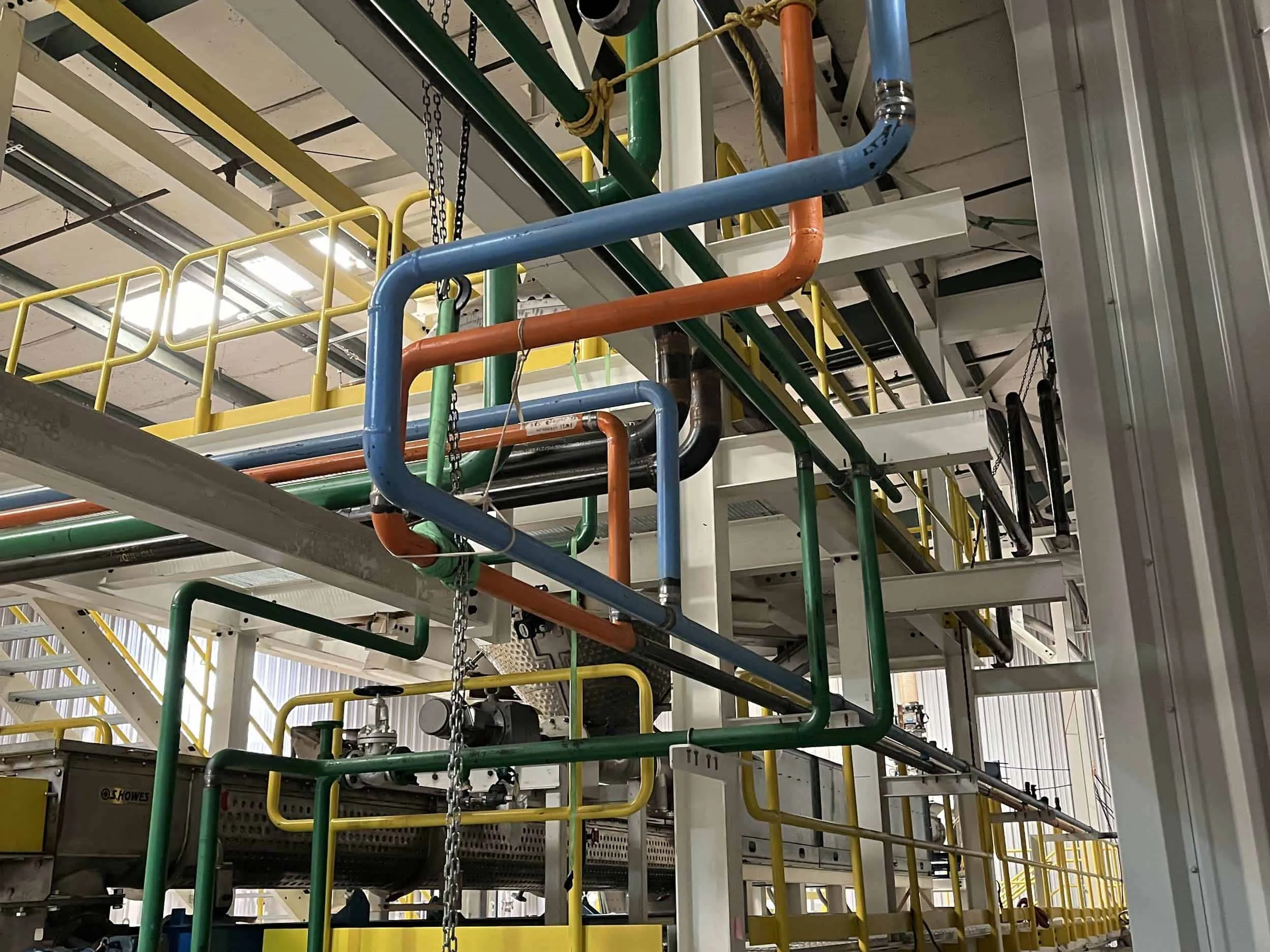 Industrial pipes in a factory setting with walkways.